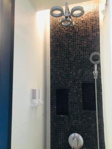 a bathroom with a shower with a tile wall at Kata Beach Guesthouse-The Beach Condo in Kata Beach