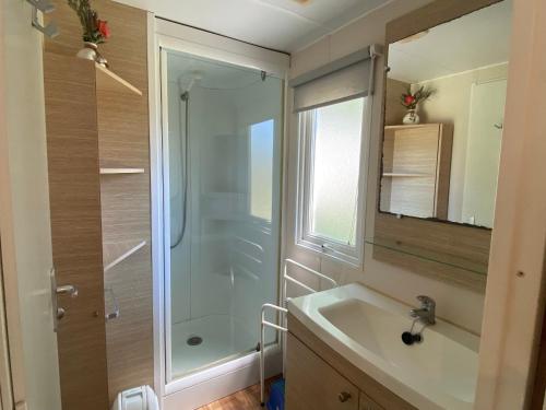 une salle de bain avec douche et lavabo dans l'établissement Mobil-home 3 chambres proche plage à Fouras, idéal 6 pers., équipement complet, calme assuré. - FR-1-709-68, à Fouras
