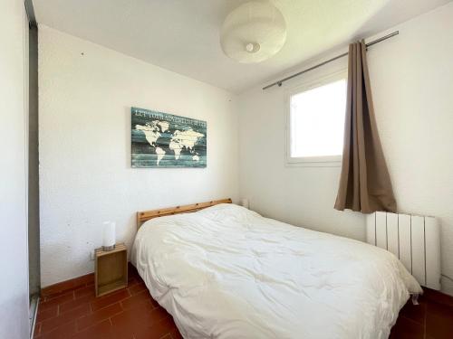 une chambre avec un lit blanc et une fenêtre dans l'établissement Appart cosy avec terrasse à 500m de la plage, parking, animaux admis, quartier dynamique - Sète - FR-1-338-494, à Sète