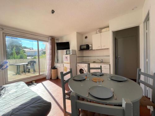 une cuisine avec une table et une salle à manger avec vue dans l'établissement Appart cosy avec terrasse à 500m de la plage, parking, animaux admis, quartier dynamique - Sète - FR-1-338-494, à Sète
