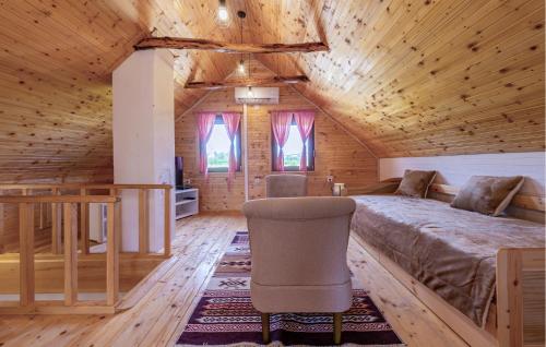 a bedroom in a log cabin with a bed and a chair at 3 Bedroom Cozy Home In Klanac in Klanac