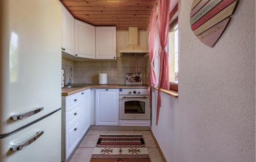 a kitchen with white cabinets and a stove at 3 Bedroom Cozy Home In Klanac in Klanac