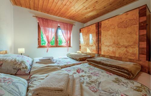 a bedroom with two beds and a wooden ceiling at 3 Bedroom Cozy Home In Klanac in Klanac
