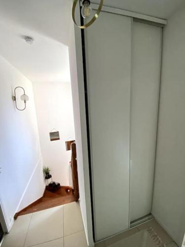 une douche avec une porte vitrée dans une salle de bain dans l'établissement Maison familiale et spacieuse, à Montpellier