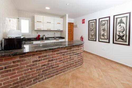 a kitchen with a brick wall and a counter at Calas Beach Corralejo in Corralejo