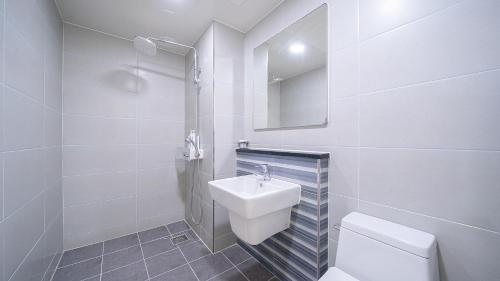 a white bathroom with a sink and a toilet at Yeosu View Foret Pension in Yeosu