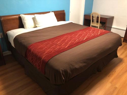 a bedroom with a bed with a red blanket at Collier's Motel in Louisville