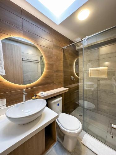 a bathroom with a toilet and a sink and a shower at Hotel Santa Elena Norte in Tunja