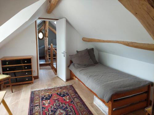a attic room with a bed and a mirror at Retraite Champêtre avec Home Cinéma et Verger Libre Cueillette, près de la Loire et des Châteaux - FR-1-590-435 in Gémigny