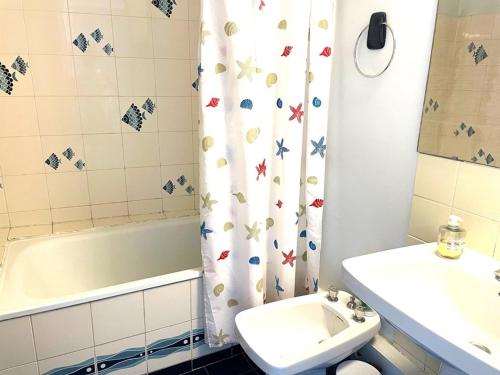 La salle de bains est pourvue d'un lavabo, de toilettes et d'un rideau de douche. dans l'établissement Studio cabine à La Grande Motte, 4 couchages, parking, proche commerces et plage - FR-1-790-31, à La Grande Motte