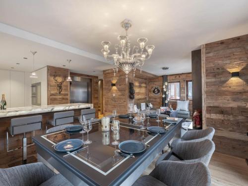 une salle à manger avec une table, des chaises et un lustre dans l'établissement Chalet cosy 4 chambres avec garage, navette gratuite et voiturette électrique, proche remontées mécaniques - FR-1-566-68, à Les Allues
