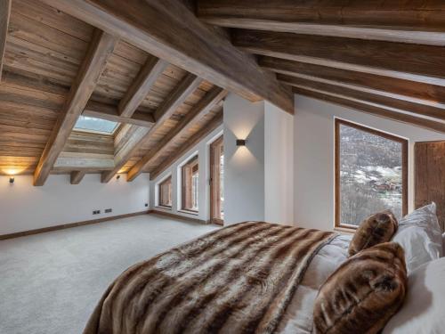 a bedroom with a large bed in a room with wooden ceilings at Chalet confortable et cosy, 4 chambres, Méribel La Gittaz - FR-1-566-68 in Les Allues