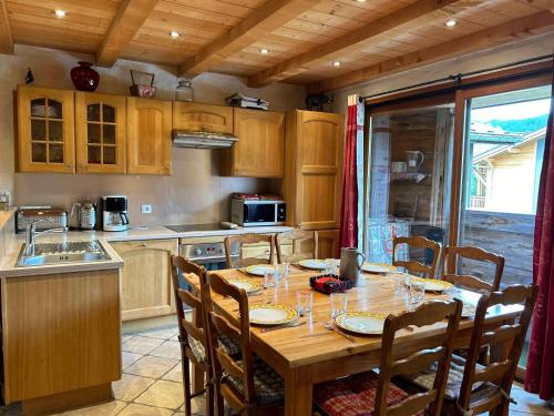 une cuisine avec une table en bois et des chaises ainsi qu'une salle à manger dans l'établissement Appartement Duplex, 6 Couchages, Proche Pistes Perrières, Balcon et Confort Moderne - FR-1-623-359, aux Gets