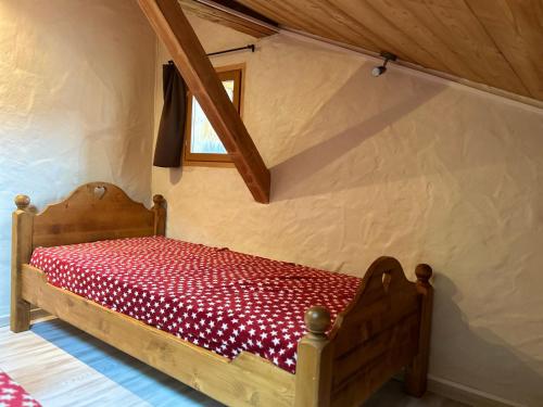 - une chambre avec un lit en bois et une couverture rouge dans l'établissement Appartement Duplex, 6 Couchages, Proche Pistes Perrières, Balcon et Confort Moderne - FR-1-623-359, aux Gets
