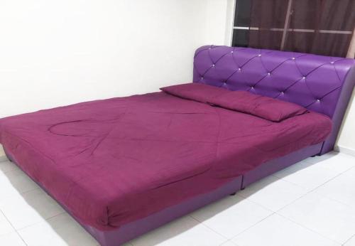 a purple bed in a white room with at Hotel Iskandar Perak in Seri Iskandar