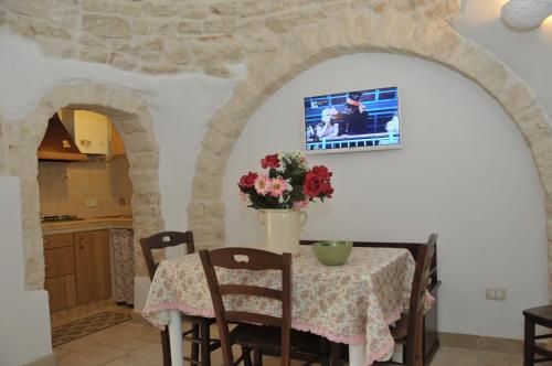 una cucina con un tavolo con un vaso di fiori di Trullo Relax ad Alberobello