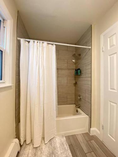 Un baño con bañera y cortina de ducha. en Live in NYC -20 Mins to Rockefeller, MoMA & World, en Jersey City
