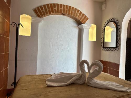 a room with two swans sitting on a bed at Hotel Casa Blanca Antigua Guatemala in Antigua Guatemala