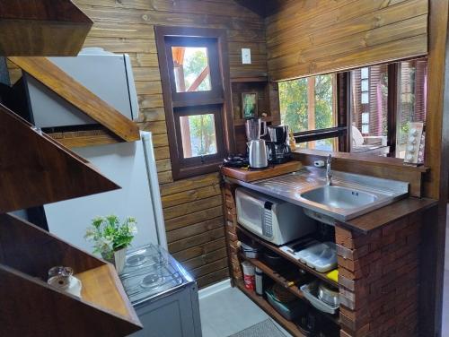 ノーヴァ・ペトローポリスにあるCabana com banheira na colinaのシンクとカウンタートップのあるキッチン