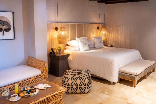 a bedroom with a bed and a table and chairs at Hotel Casa Don Luis by Faranda Boutique, a member of Radisson Individuals in Cartagena de Indias