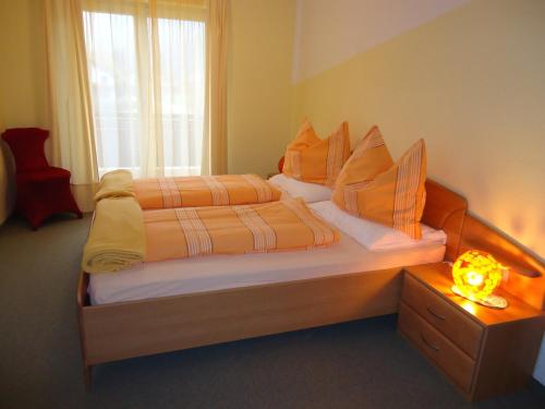 Pension Königshof في مالنيتز: غرفة نوم بسرير كبير وملاءات برتقالية وصفراء