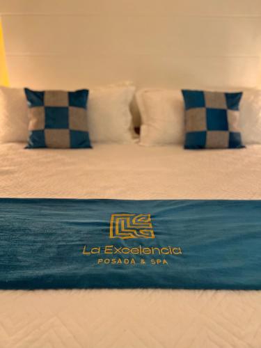 a bed with a blue blanket on top of it at La Excelencia Posada & Spa in San Cristóbal