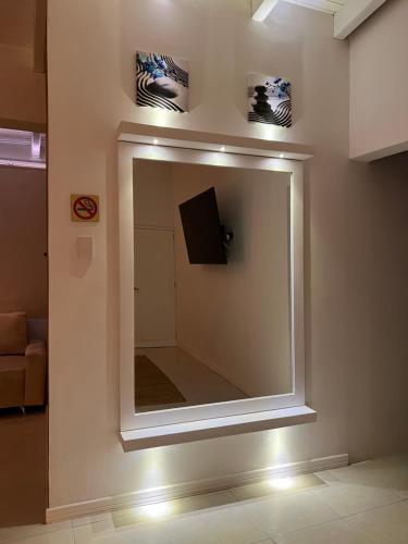 a mirror on a wall with a television in a room at La Excelencia Posada & Spa in San Cristóbal