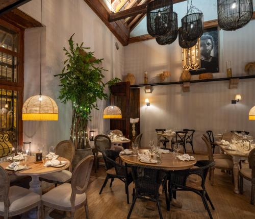 a dining room with tables and chairs and chandeliers at Hotel Casa Don Luis by Faranda Boutique, a member of Radisson Individuals in Cartagena de Indias