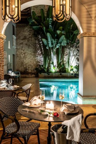 a dining room with a table and a swimming pool at Hotel Casa Don Luis by Faranda Boutique, a member of Radisson Individuals in Cartagena de Indias