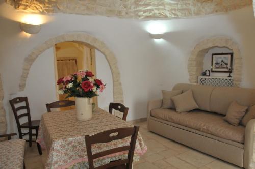 un soggiorno con un tavolo e un divano di Trullo Relax ad Alberobello