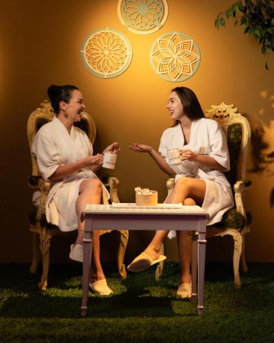 two women sitting in chairs in a room with a table at La Excelencia Posada & Spa in San Cristóbal