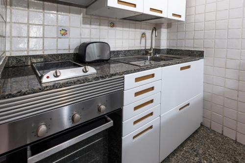 a small kitchen with a sink and a stove at Calas Beach Corralejo in Corralejo