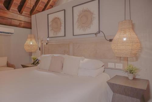 a bedroom with a white bed and two pendant lights at Hotel Casa Don Luis by Faranda Boutique, a member of Radisson Individuals in Cartagena de Indias