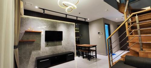 a living room with a staircase and a dining room at 2 BR Apartment Grand Jati Junction Medan view City 12th Floor in Medan