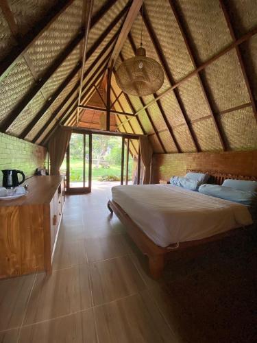 a bedroom with a large bed in a room at Lembah Cinta Mayungan in Baturiti