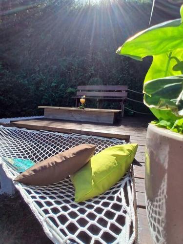 a hammock with two pillows sitting on a patio at Fare Ohiti, face au spot de surf de Haapiti in Haapiti