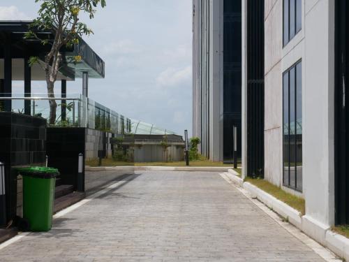 an empty street in a city with tall buildings at Meisterstadt Pollux Habibie in Batam Center