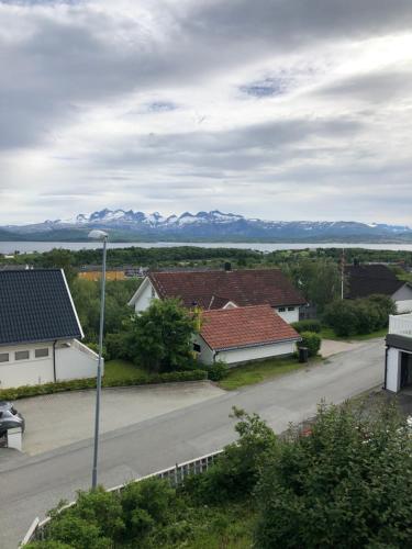 a street with houses and mountains in the distance at Private room on quiet street in Bodø