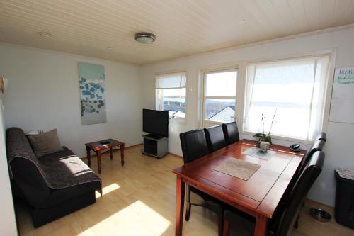 a living room with a dining room table and a couch at Private room on quiet street in Bodø