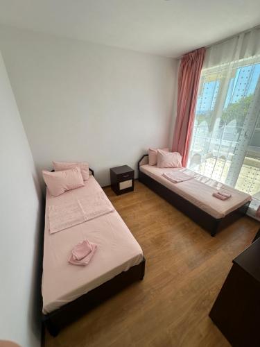 twee bedden in een kamer met een raam bij Apartament Savva in Byala