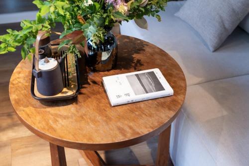 a table with a book and a vase with flowers on it at Beijing Le Zai Nan Luo Gu Xiang Wang Fu Jing Forbidden City Courtyard Hotel&Free laundry service&Free coffee &Paid Dumpling experience service in Beijing