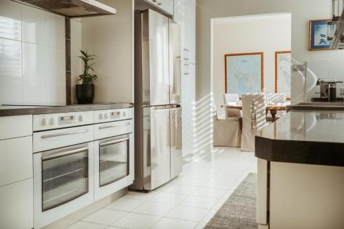 a kitchen with white cabinets and stainless steel appliances at ONE Luxury Apartment in Devonport