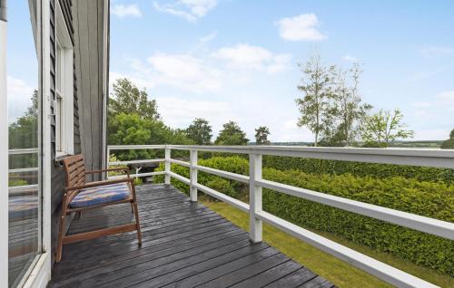 a wooden porch with a chair on a balcony at Awesome Home In Skibby With Wifi in Skibby