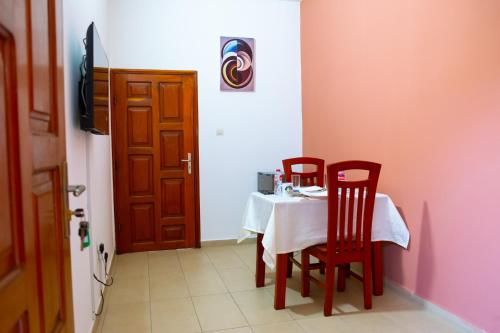 a room with a table and two chairs and a door at JRéside Appart SOLO-DUO 30m2 centre ville in Cotonou