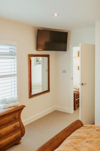 a bedroom with a mirror and a bed and a dresser at ONE Luxury Apartment in Devonport