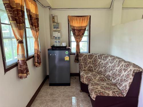 a living room with a couch and a refrigerator at JJ&J Garden in Pai
