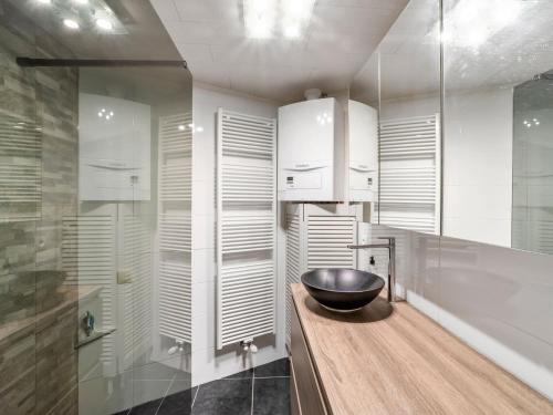 a bathroom with a bowl sink on a wooden counter at Ideal holiday home with garage in Blankenberge