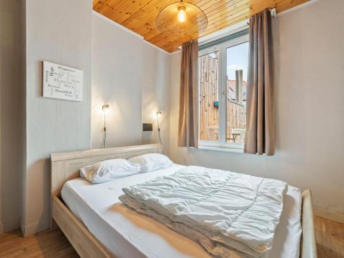 a bed in a bedroom with a window at Ideal holiday home with garage in Blankenberge