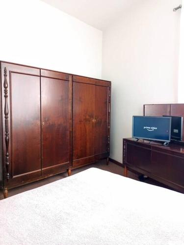 a large wooden cabinet in a room with a tv at Central, Aconchegante e Retrô in Curitiba