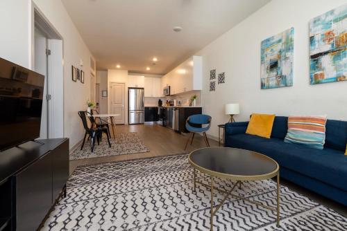a living room with a blue couch and a table at Stunning Nulu 1BR CozySuites 06 in Louisville